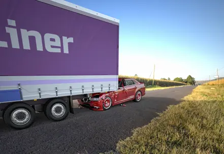 A red coupé/sedan against the back of a big truck.