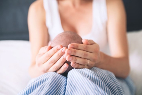 mother cupping infant's head