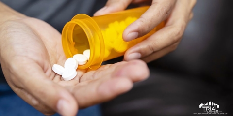 Spilling pills from a bottle into hands.