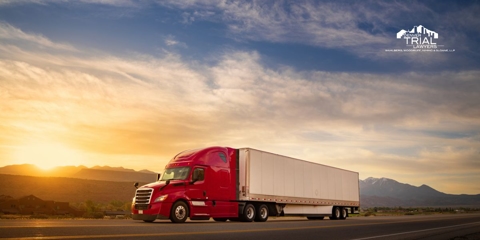 Red semi truck with white trailer on a highway.