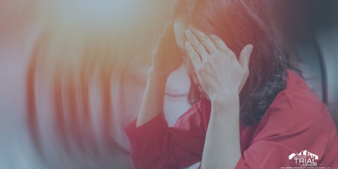 Asian woman holding her fingers to each side of her temple.