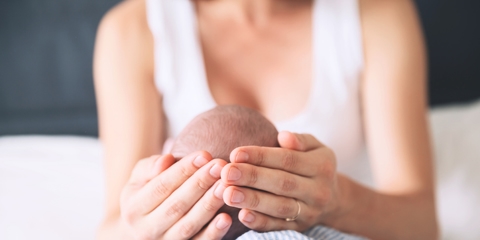 mother cupping infant's head