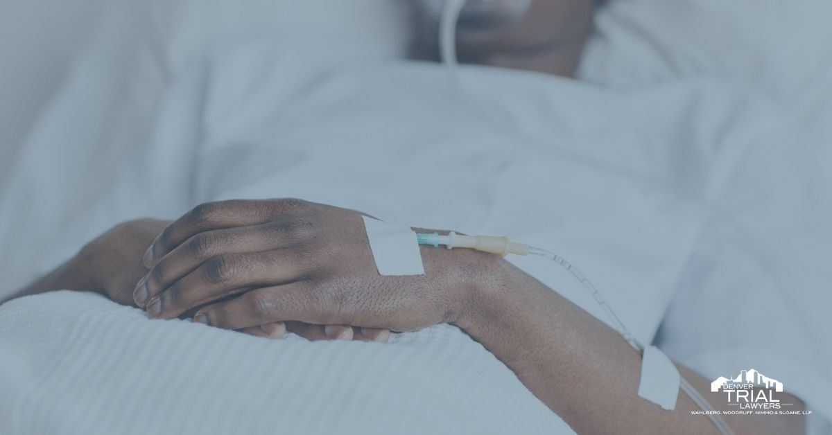 Man lying in hospital bed with folded hands and IV tube on the back of his hand