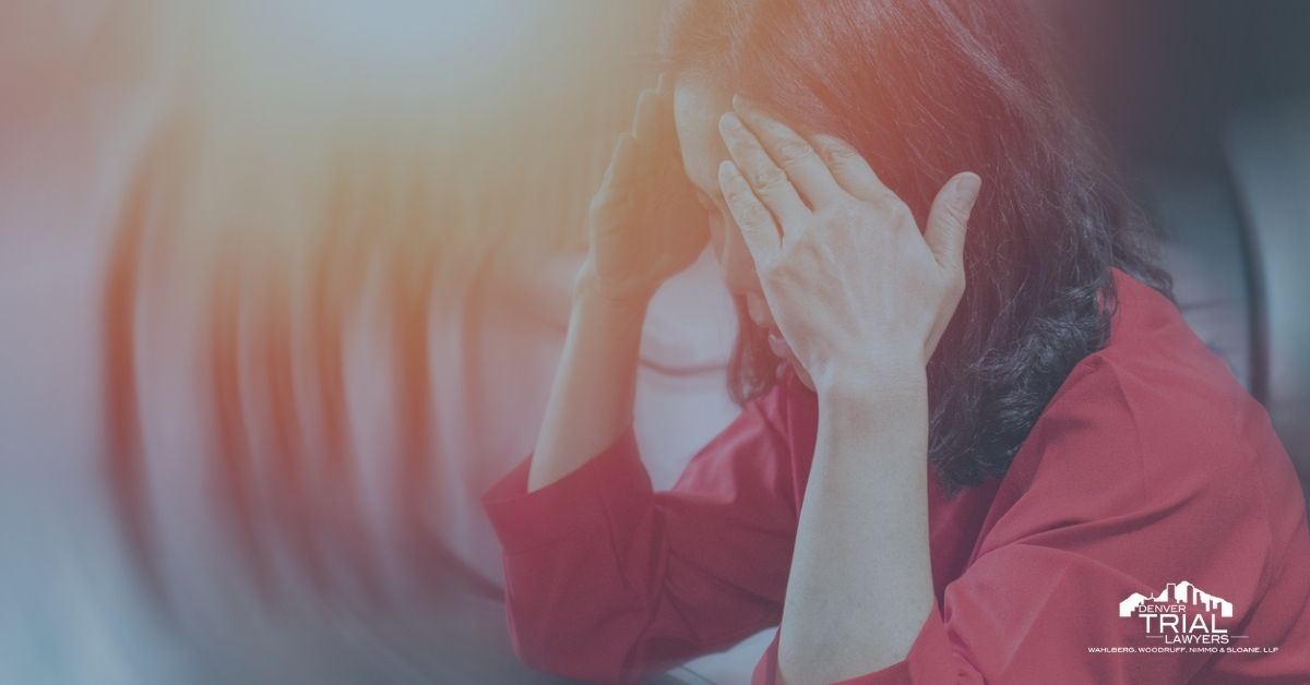 Asian woman holding her fingers to each side of her temple.